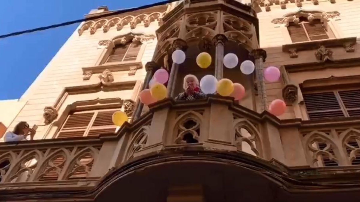 Pilar Fontana al balcó de casa seva rodejada de globus.