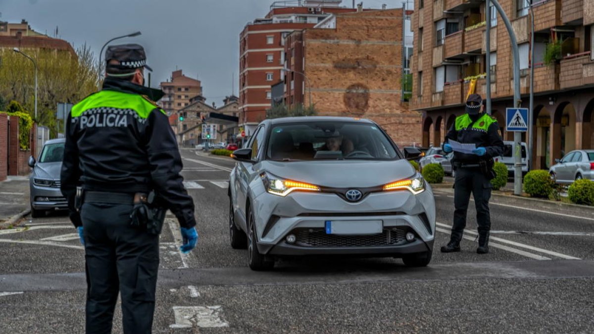 Dos agentes de la Policía Local de Mollerussa haciendo un control para comprobar que se cumplen las medidas de confinamiento.