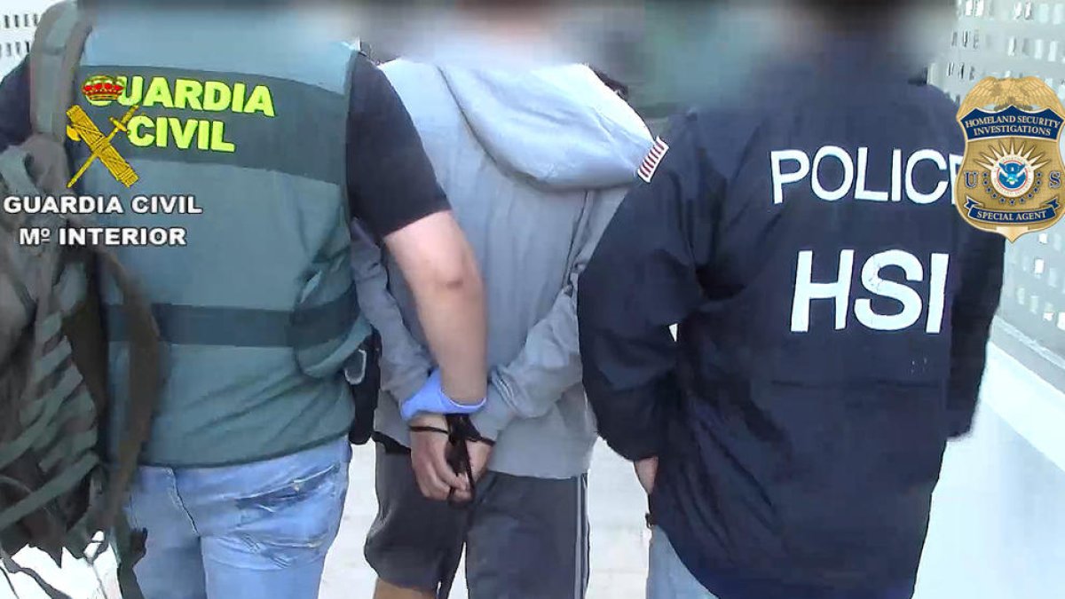 Pla obert de dos agents de la Guàrdia Civil detenint un membre de la organització criminal.