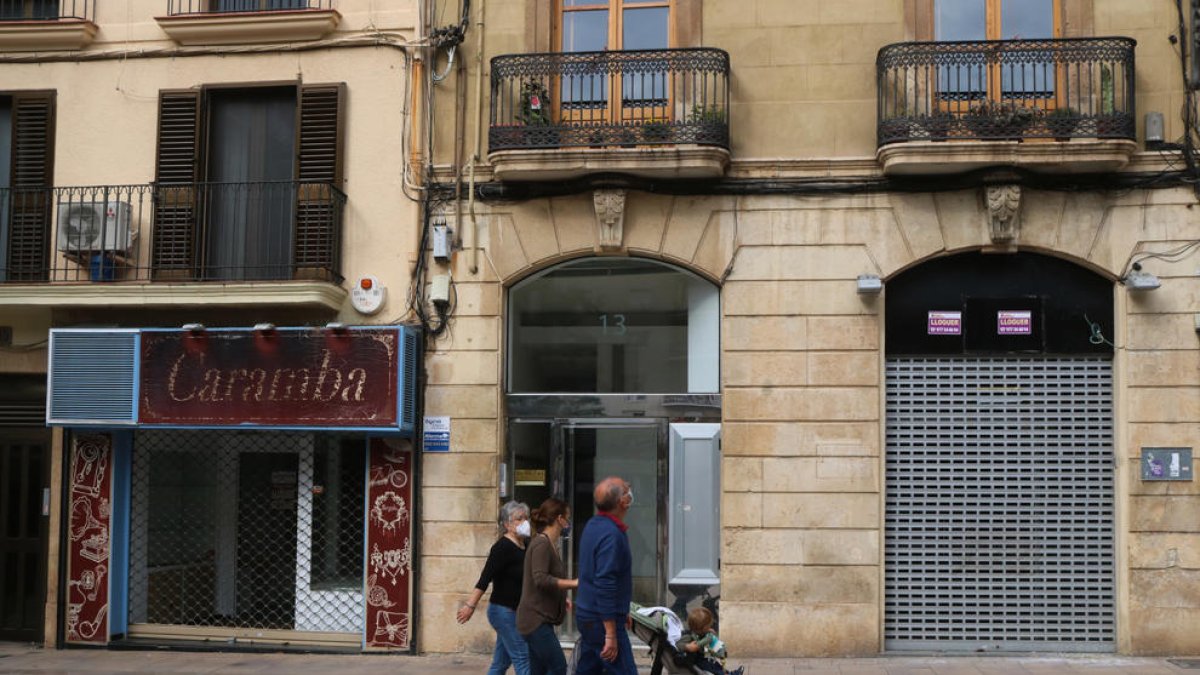 Dos locals tancats al carrer Sant Agustí de Tarragona amb un grup de persones caminant per davant