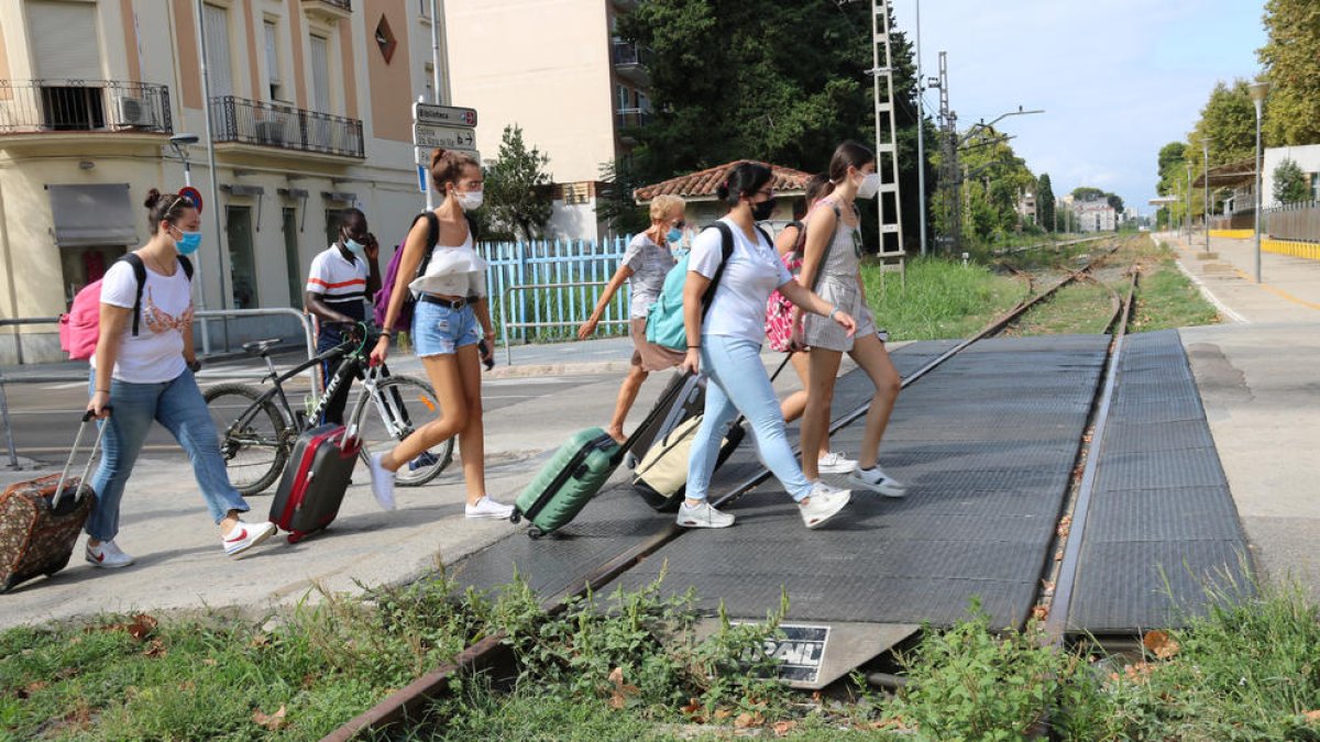 Un grupo de turistas cruzando la antigua vía del tren en el centro de Salou.