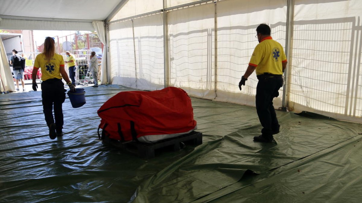 Plano medio donde se pueden ver técnicos del SEM llevándose la carpa que se había montado