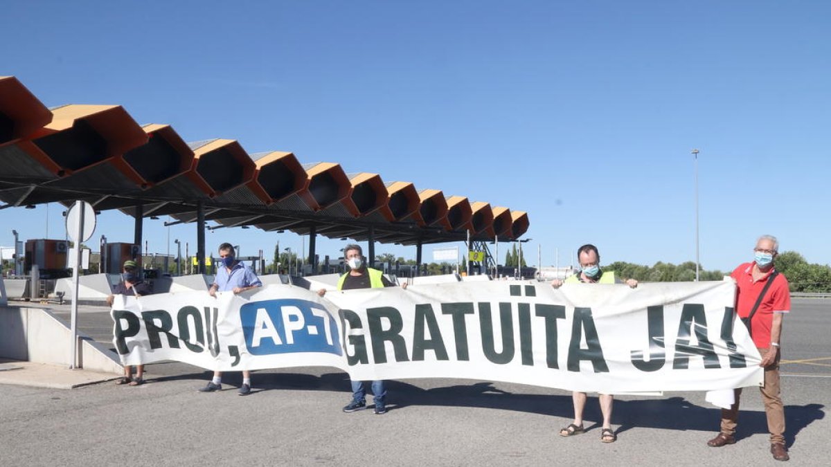 Pla general de membres de la plataforma 'Prou! AP-7 Gratuïta Ja!' en l'acció a l'accés de l'autopista AP-7 de Salou.