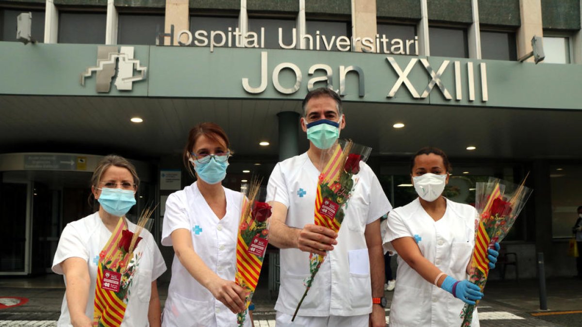 Quatre professionals sanitaris del Joan XXIII de Tarragona amb la seva rosa solidària a les mans.