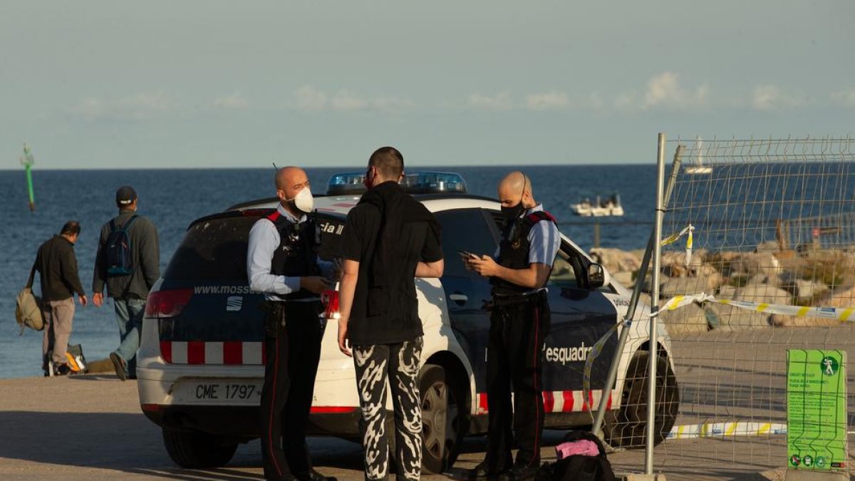 Los Mossos multando a una persona en BArcelona para hacer deporte a una zona prohibida.