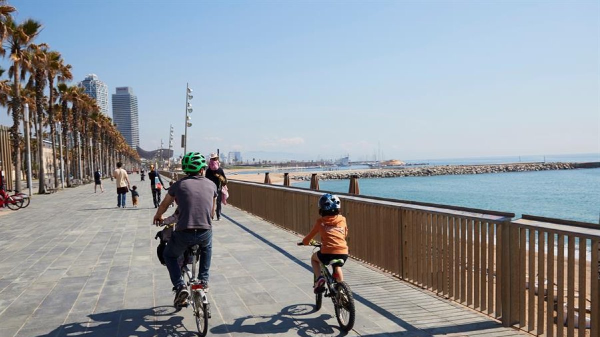 Una familia circula en bici por el paseo marítimo de Barcelona este domingo.