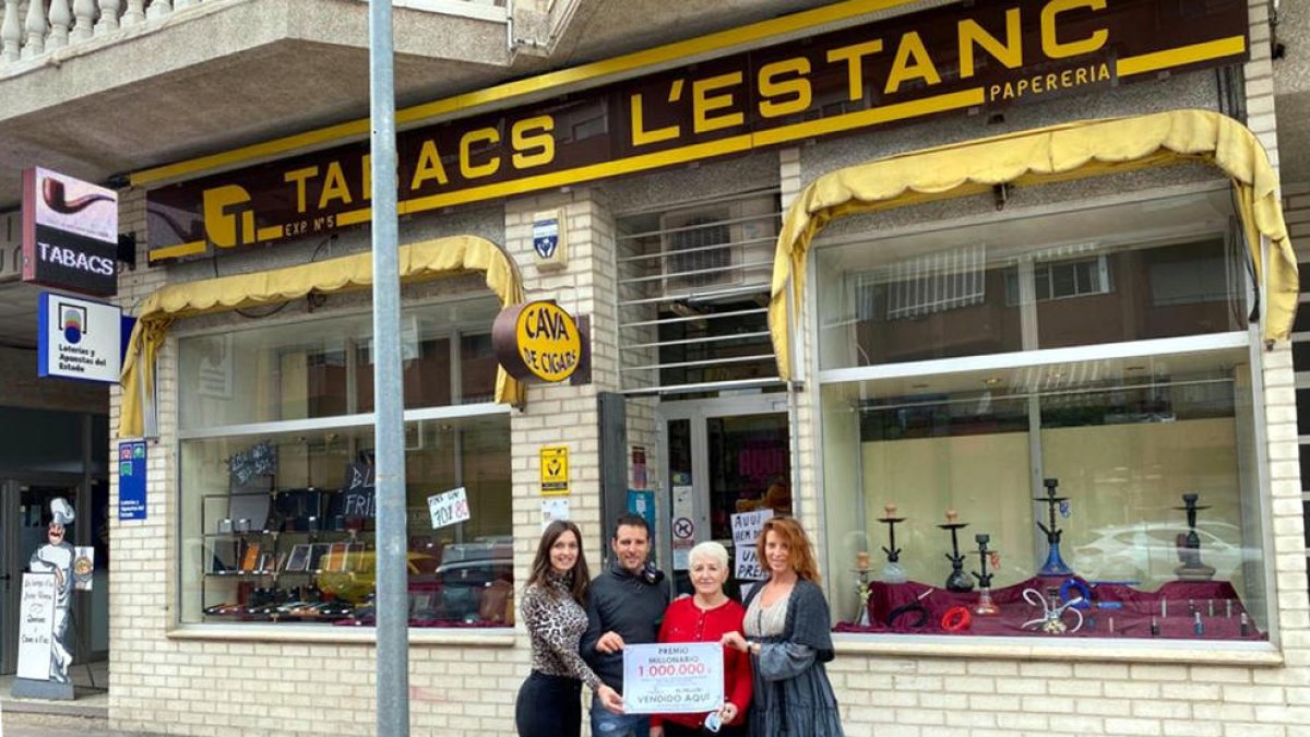 Los responsables y trabajadores del estanco de Amposta con el cartel que anuncia el premio de 1 MEUR que han repartido.