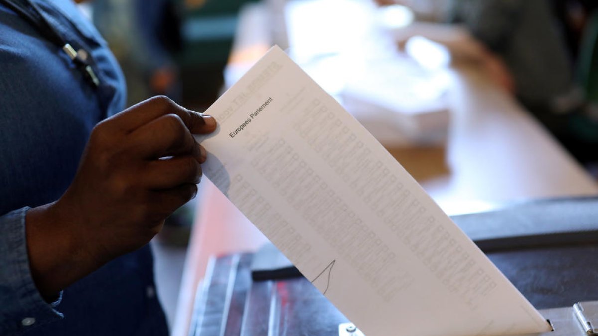 Una urna en el momento en que un ciudadano deposita su voto en unas elecciones.