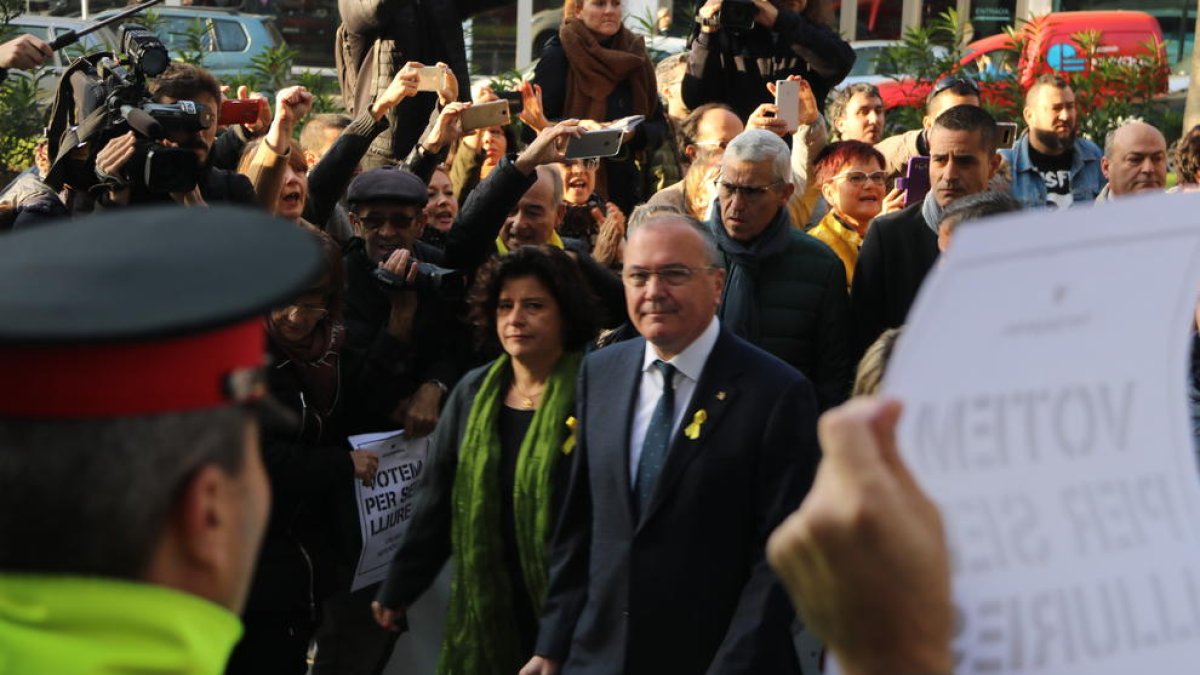 Plan|Plano medio del alcalde de Reus, Carles Pellicer, con la concejala Montserrat Vilella, entrando en el juzgado de Reus en medio de varios manifestantes.
