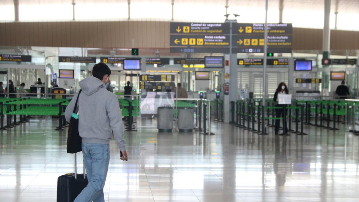 Un passatger a la zona d'arribades de la T1 de l'aeroport del Prat