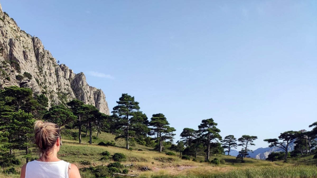 Plano medio de una chica contemplando la  Bassa de la Refoia en el Parc Natural dels Ports.