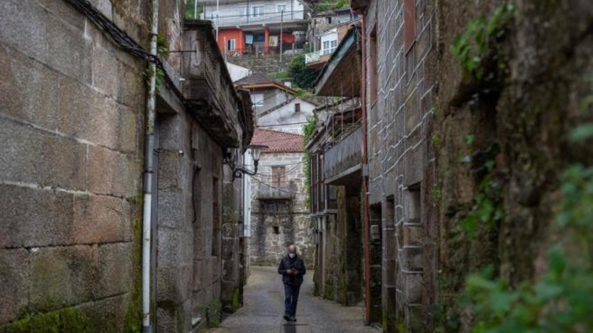 Un home camina pels carrers de Beade.