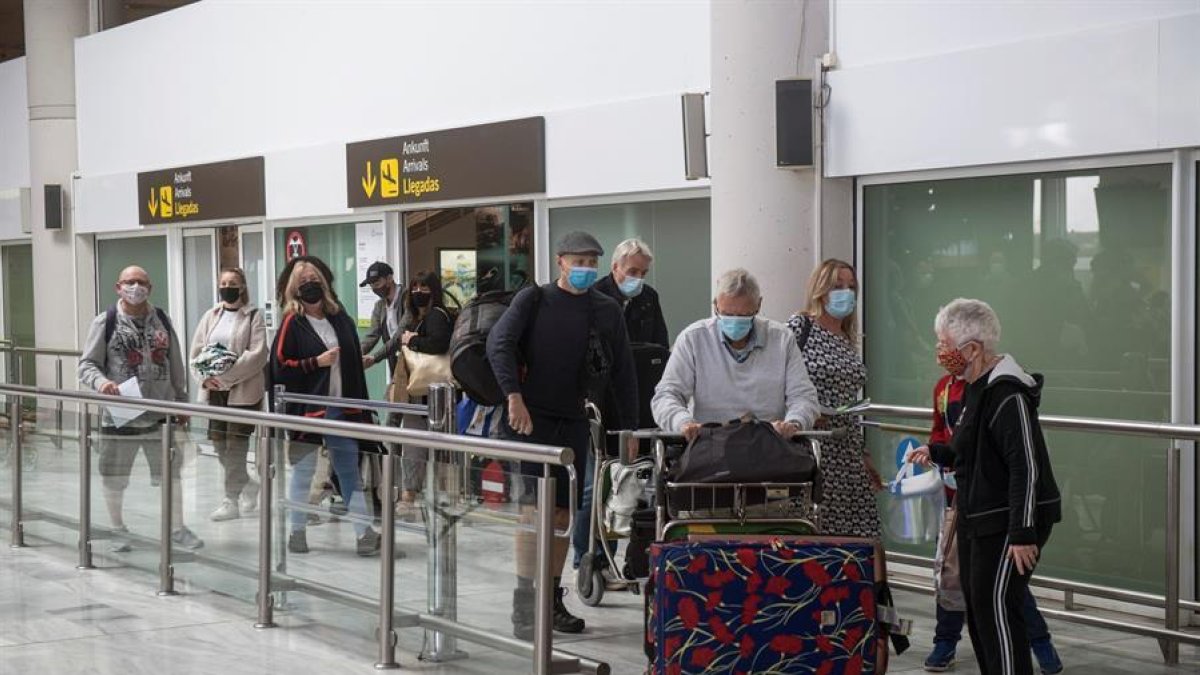 Varios turistas salen de la sala de recogida de equipajes a su llegada al aeropuerto César Manrique de Lanzarote.