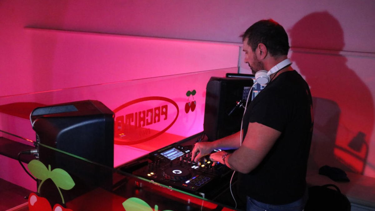 Un DJ posant música en un bar musical.