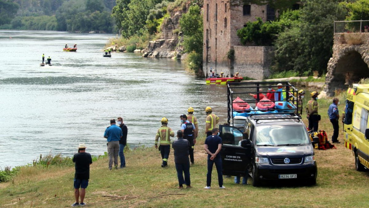 Els efectius d'emergències treballant en el punt on es fa la recerca del jove desaparegut al riu Ebre a l'alçada de Miravet.
