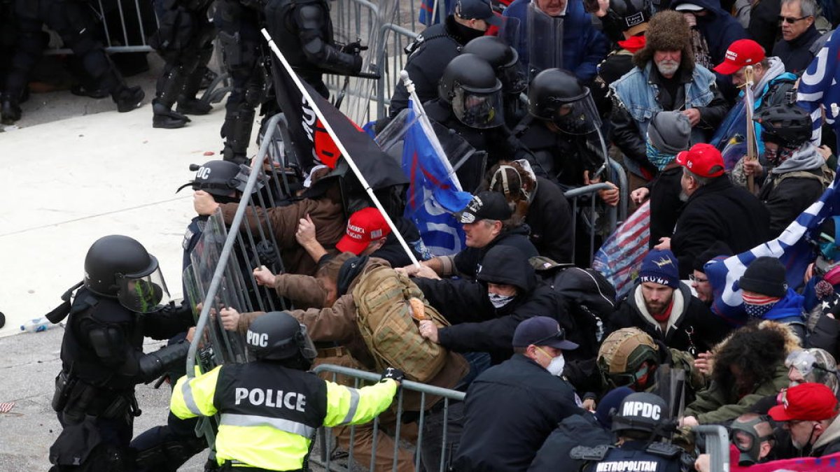 La policía intentando contener a los manifestantes pro-Trump en el exterior del edificio del Capitolio de los Estados Unidos.