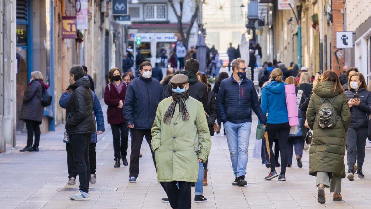 Gente paseando por Tarragona con mascarillas.