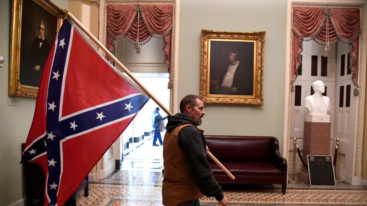 Un partidari del president Donald Trump porta la bandera confederada en l'assalt al Capitoli dels Estats Units, a Washington.