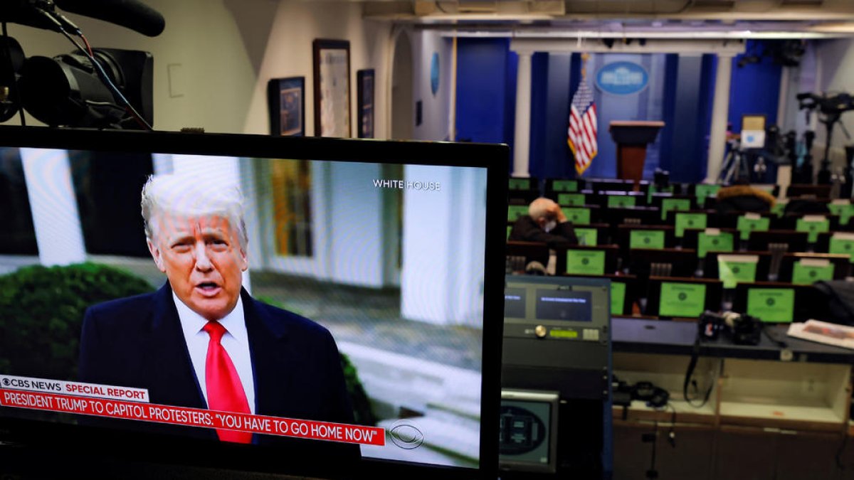 Donald Trump haciendo declaraciones en un monitor de televisión desde la sala de información de la Casa Blanca, después del asalto al Capitolio.