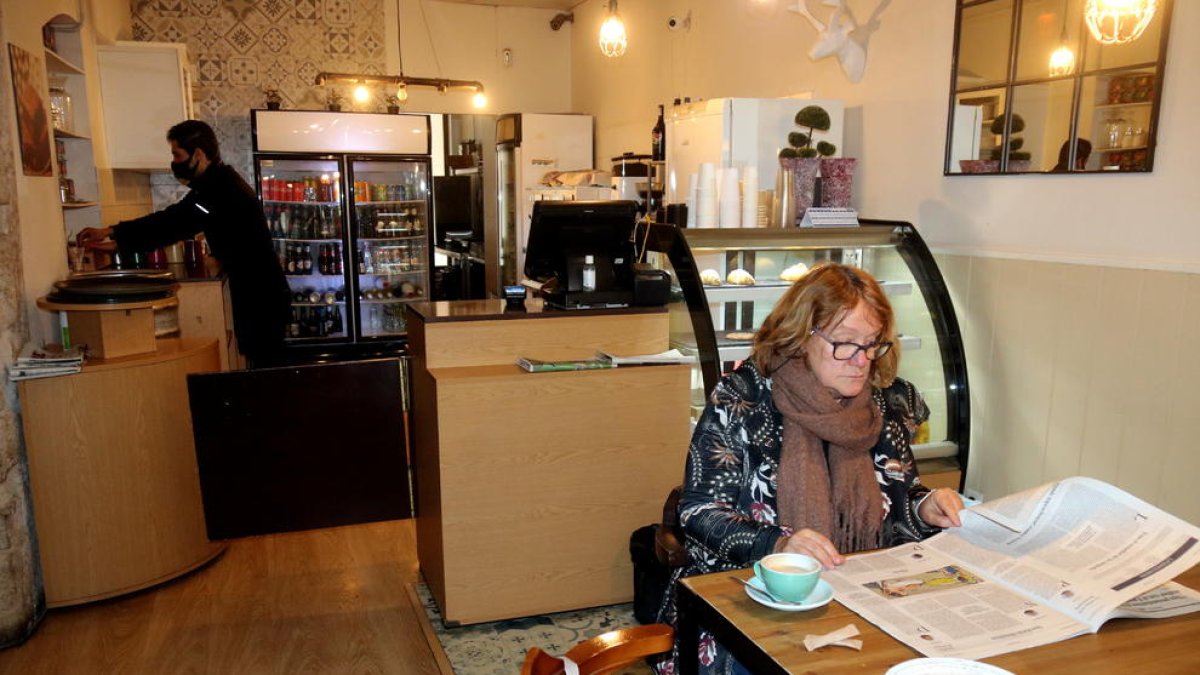 Una cliente desayunando en un bar.