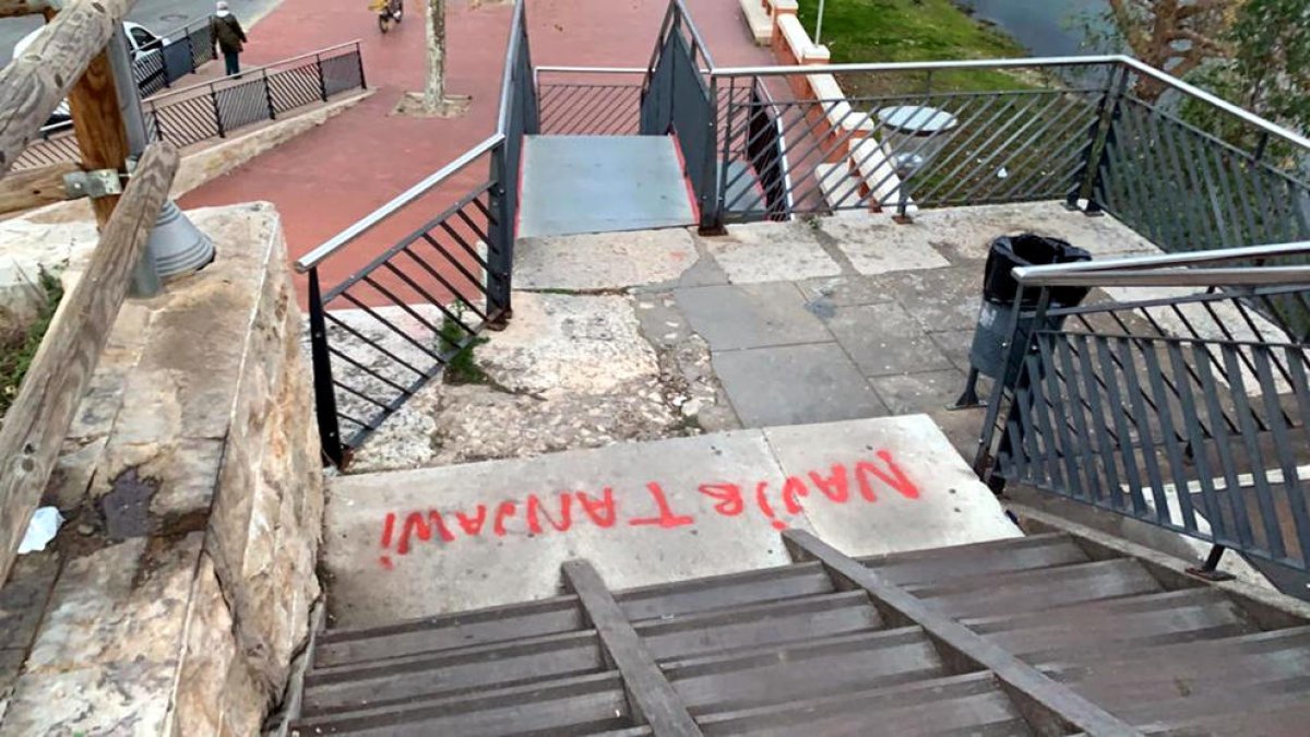 Una de las pintadas que hicieron los jóvenes en las escaleras de acceso al puente rojo de Tortosa desde el barrio de Ferreries.