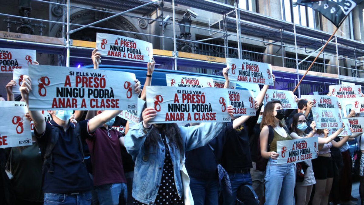 Carteles durante una manifestación en el centro de Barcelona para protestar porque un grupo de estudiantes están encausados por|para desórdenes durante una huelga del 2017 donde pedían la rebaja de tasas universitarias