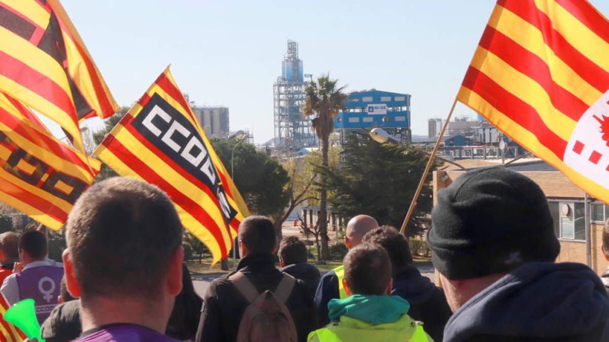 Treballadors camí de la porta d'IQOXE, durant la vaga al sector petroquímic de Tarragona, amb l'empresa al fons.