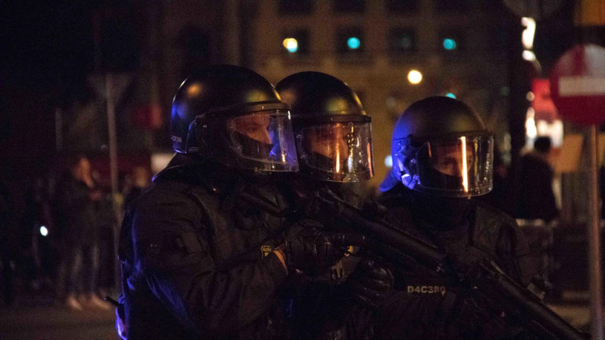 Tres antidisturbios de los Mossos con pistolas de foam en el centro de Barcelona.