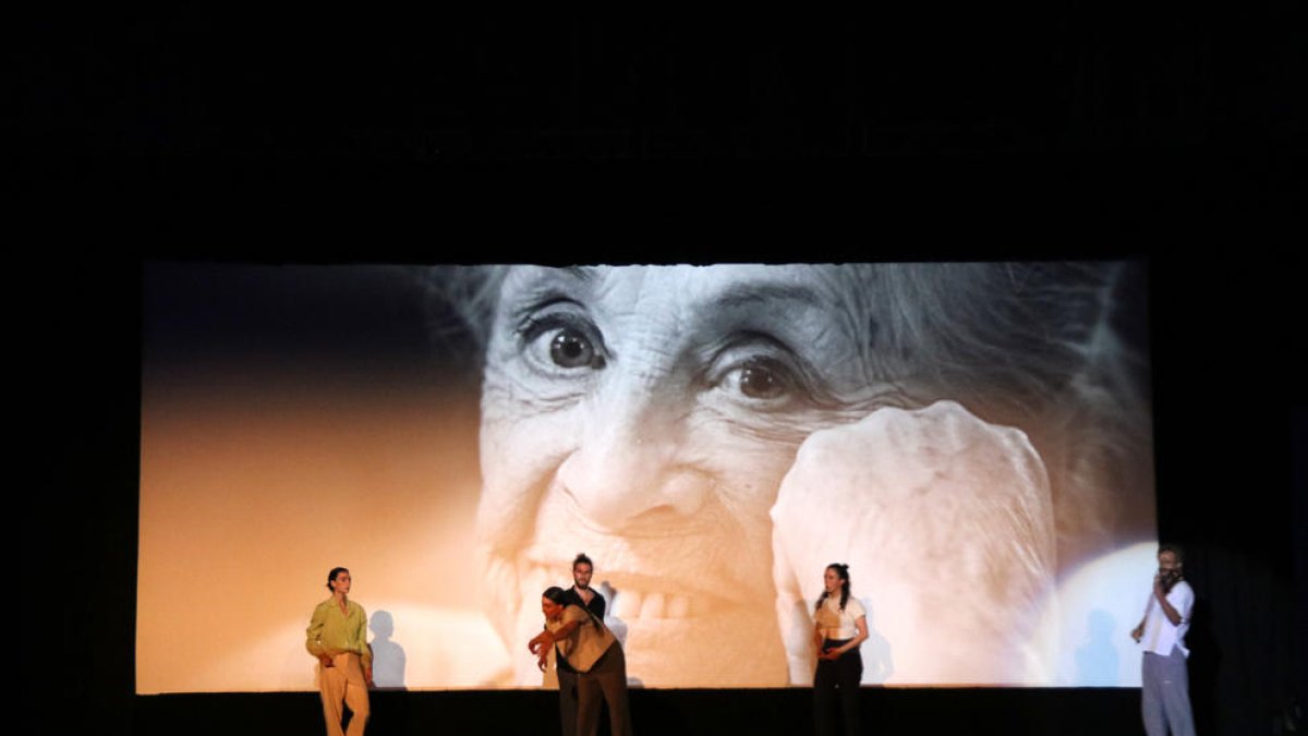 Ballarins actuant a l'escenari del FIC-CAT amb la imatge de Montserrat Carulla a la pantalla, durant l'homenatge a l'actriu.