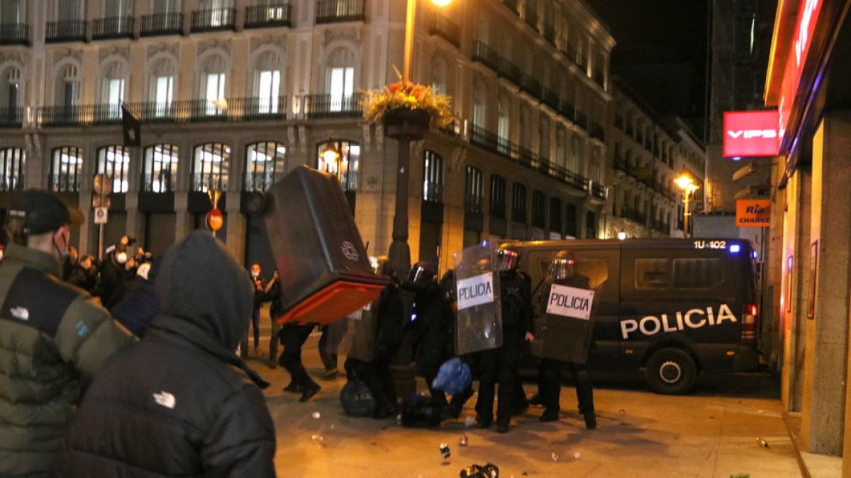 Un contenidor d'escombraries volant en els enfrontaments a la Puerta del Sol de Madrid en la protesta proHasel, el 17 de febrer del 2021.