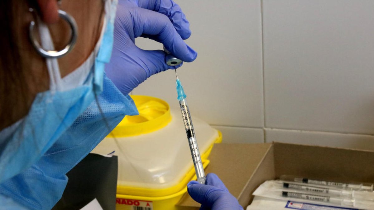 Una infermera preparant una injecció de la vacuna contra la covid-19.