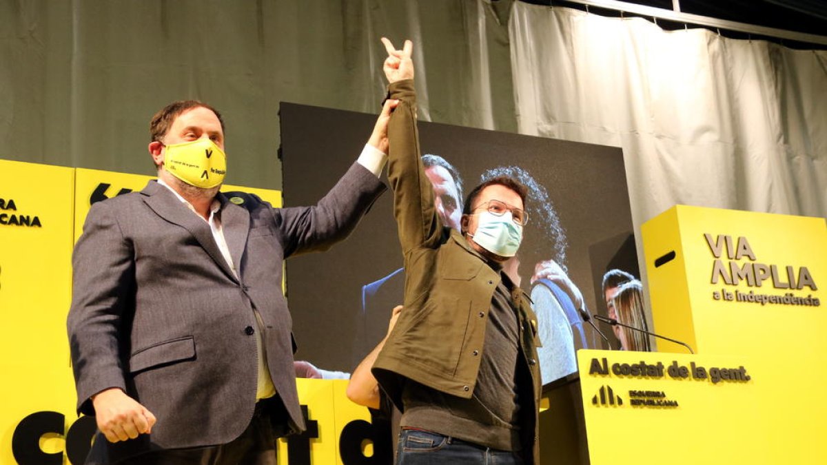 Oriol Junqueras i Pere Aragonès saludant al públic durant un acte de campanya.