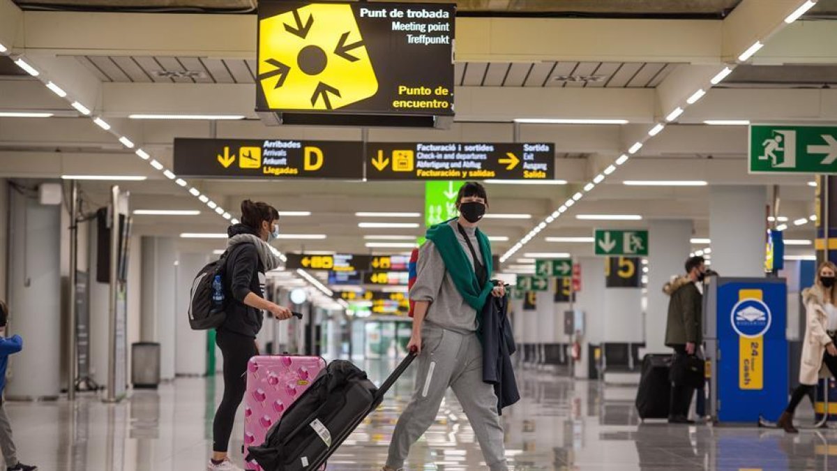 Viatgers caminen per la terminal d'arribades de l'aeroport de Palma.