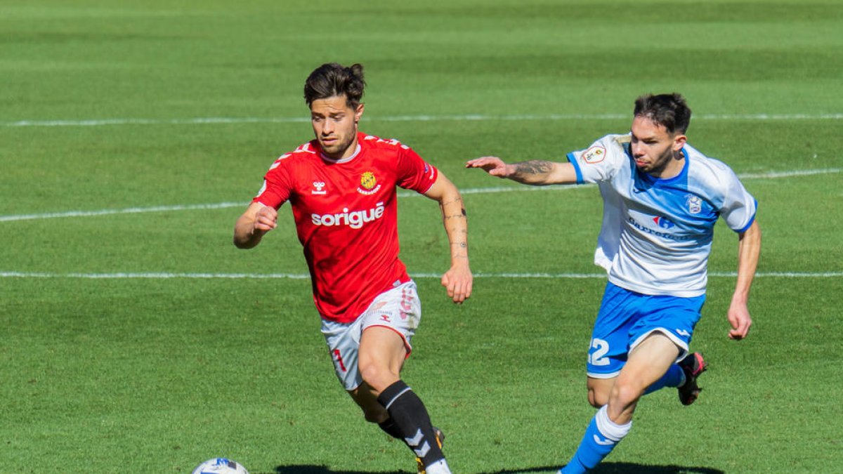 Un jugador del Nàstic perseguido por uno del Prat.