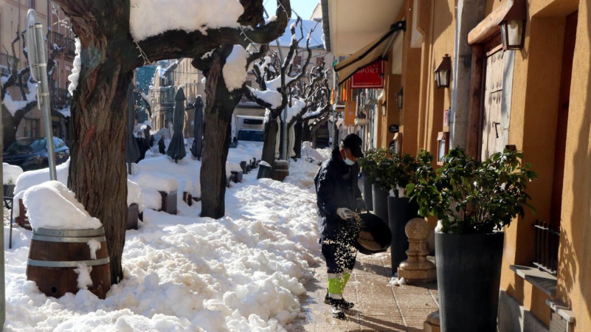 Pla obert d'un efectiu de la brigada muniicpal de Falset espargint sal en un cèntric carrer de la capital del Priorat