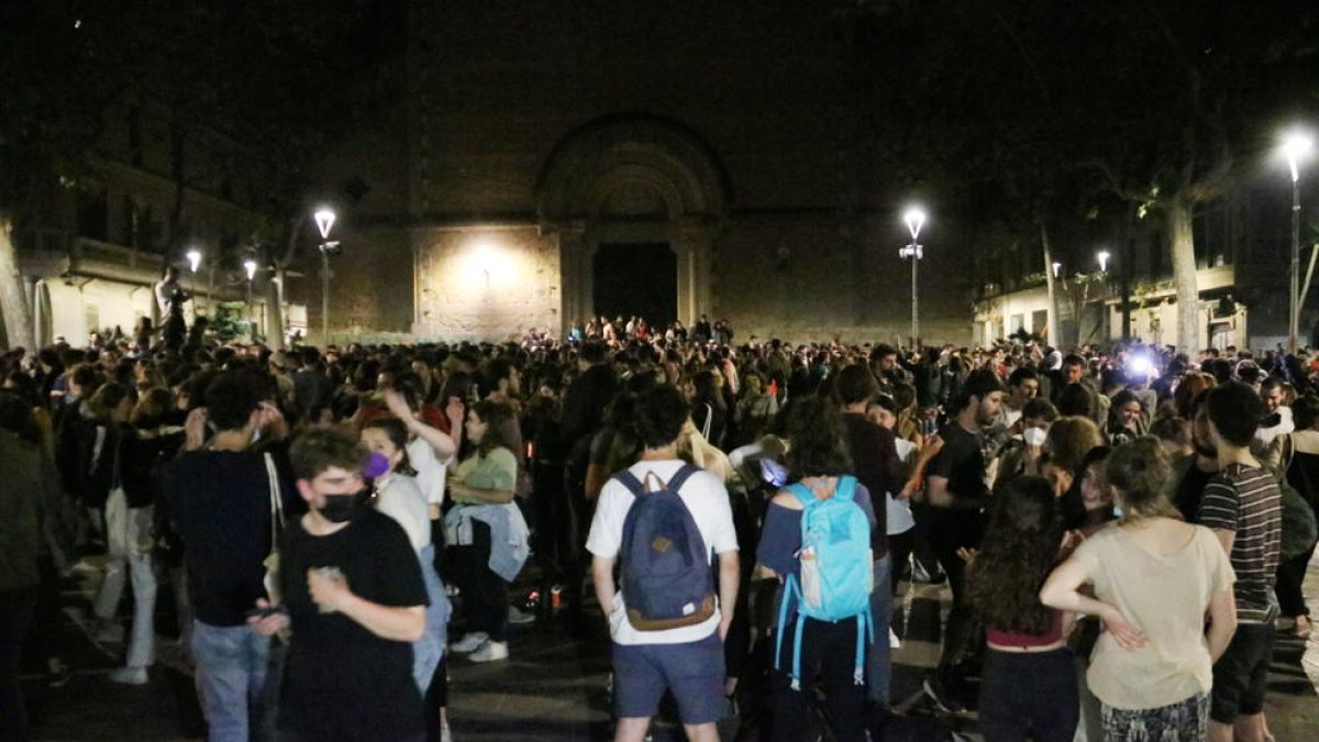 Centenars de joves celebran la caiguda del toc de queda a la plaça de la Virreina de Barcelona.