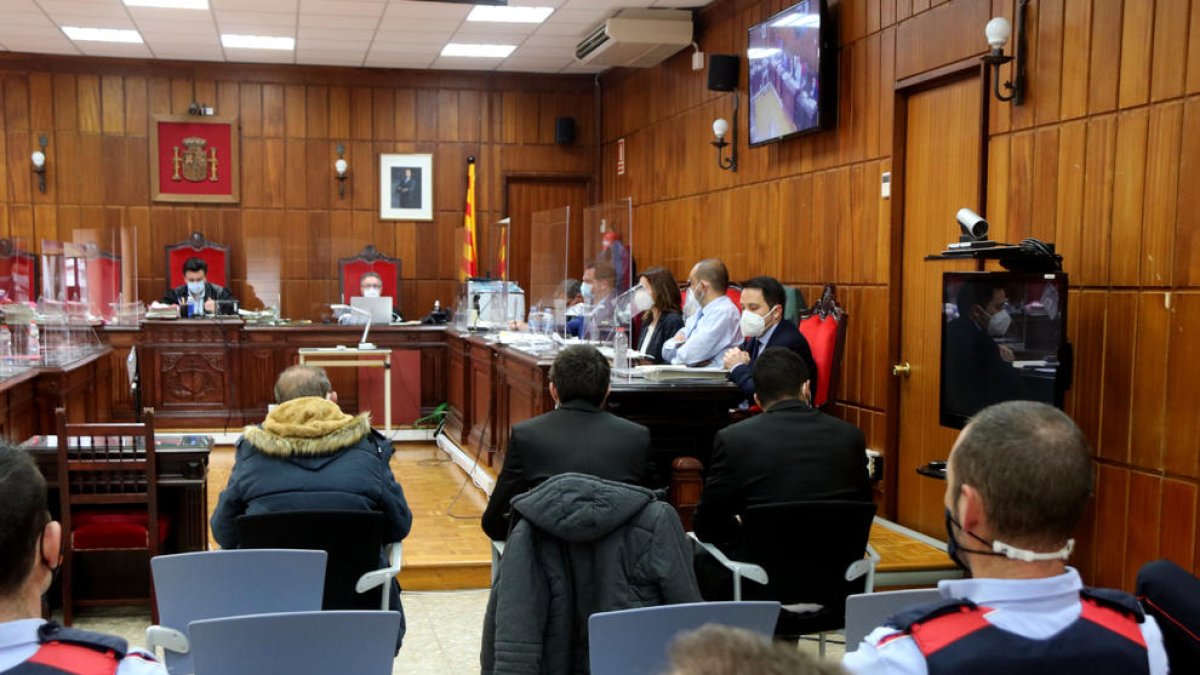 Plano medio de los tres acusados por el homicidio de un hombre en el Montmell -de izquierda en derecha, José, Joaquín y Bacari- sentados de espaldas en la sala de vistas de la Audiencia de Tarragona.
