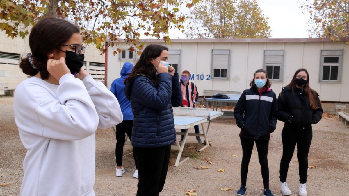 Dues alumnes de l'Institut d'Alcanar explicant els bons usos de la mascareta als seus companys.