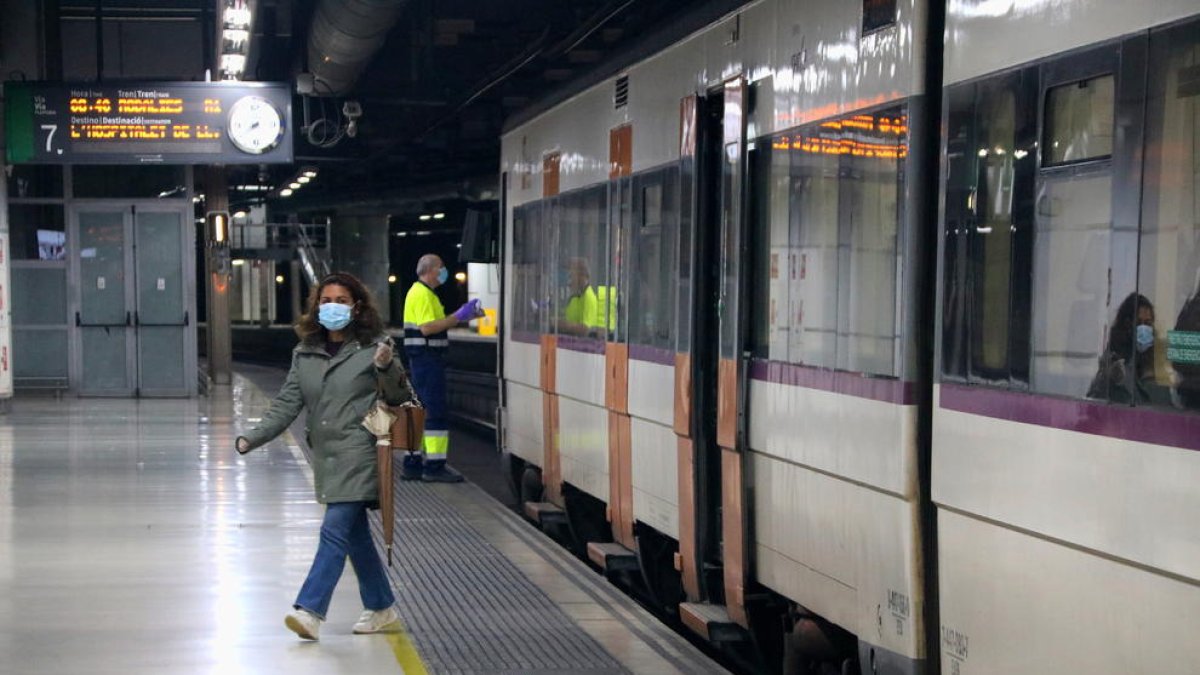 Pla obert d'una usuària de Rodalies sortint d'un tren a l'andana de l'estació de Sants de Barcelona.
