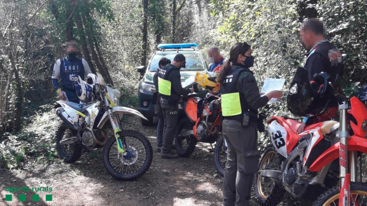 Unos Agentes Rurales multando a unos motoristas en Riudaura.