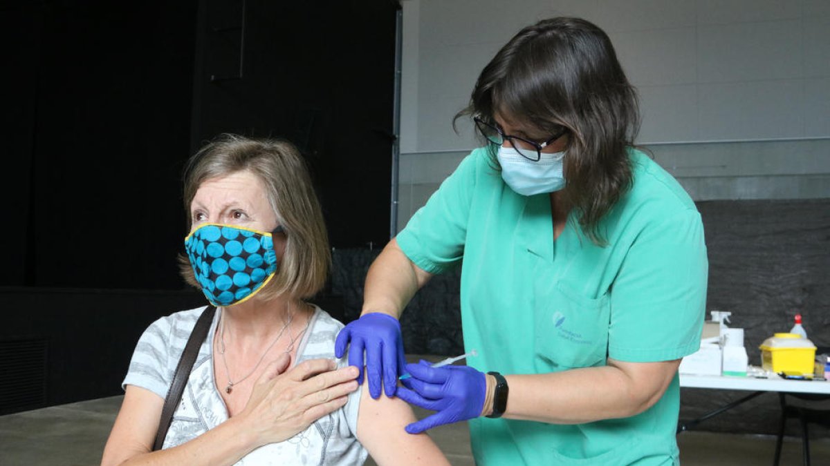Una dona rebent una dosi de vacuna anticovid.