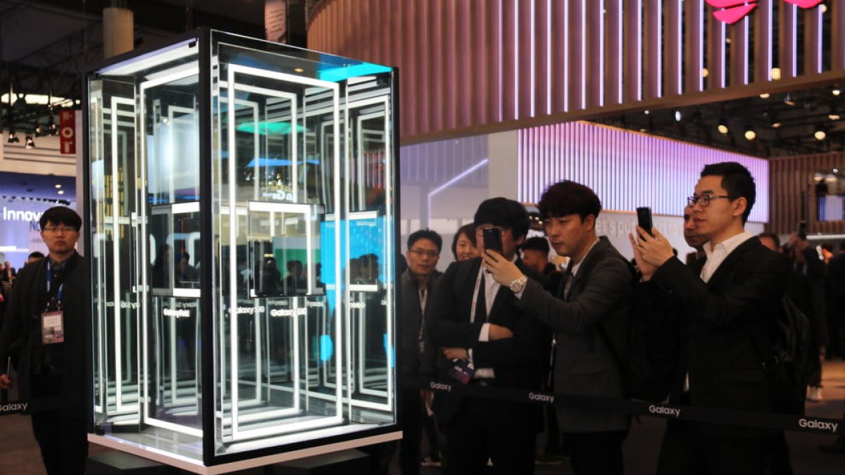 Varias personas hacen fotografías al nuevo móvil de Samsung, en el Mobile World Congress, el 25 de febrero