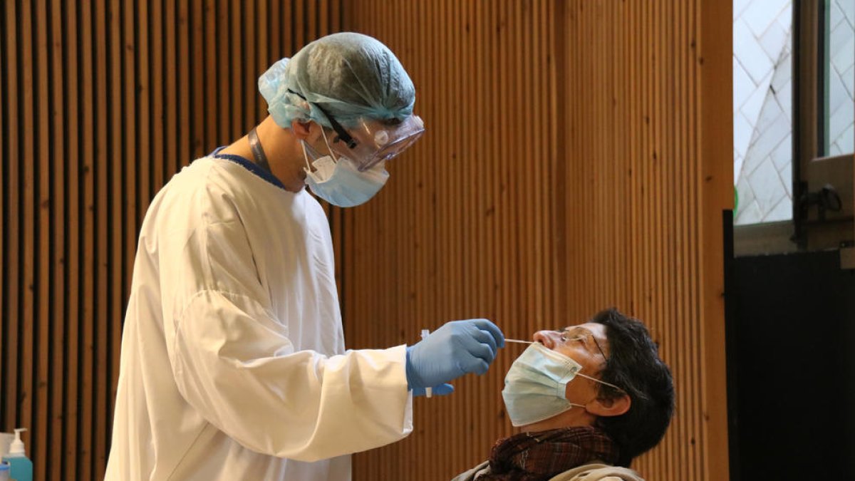Una dona fent-se una prova amb test d'antígens al cribratge al recinte modernista de l'hospital Sant Pau de Barcelona.