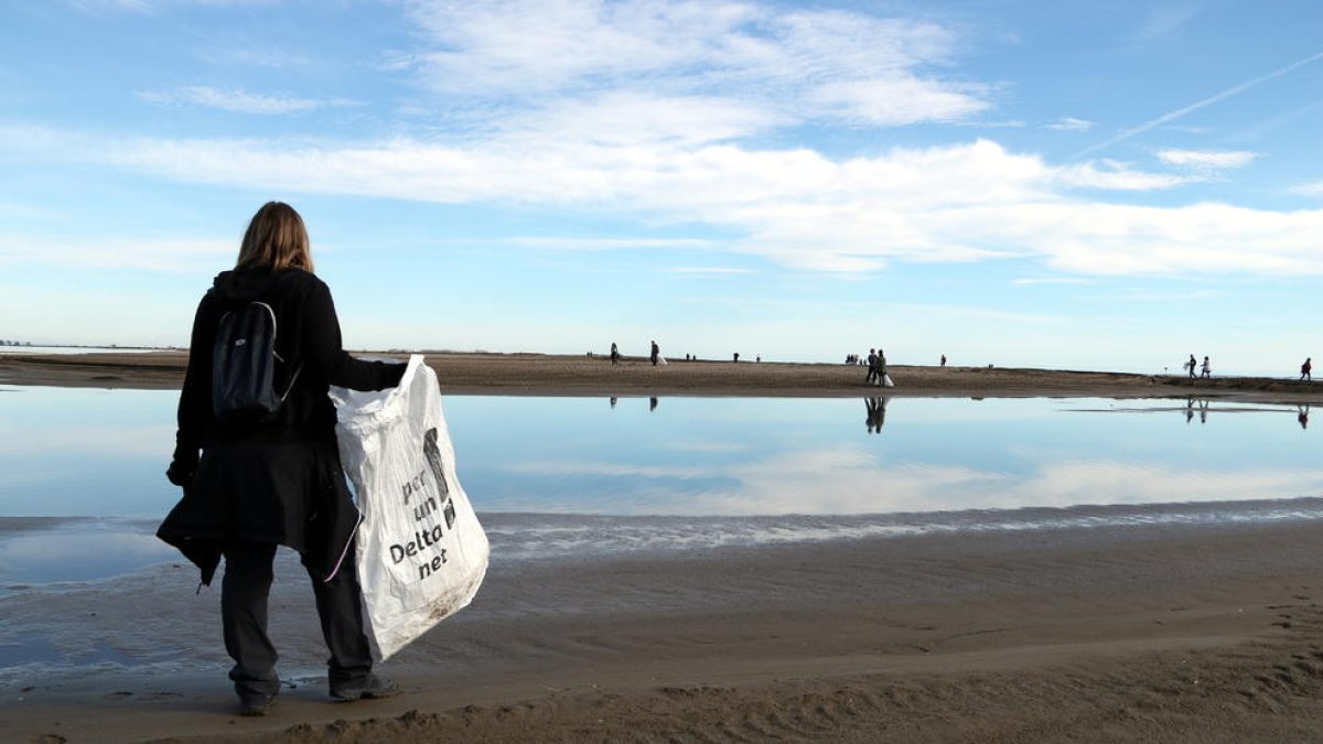 Imatge d'arxiu d'una dona durant la jornada del Dia Mundial de les Zones Humides a la platja del Trabucador.