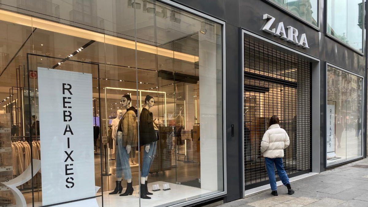 Una compradora davant d'una botiga Zara tancada al Portal de l'Àngel de Barcelona.