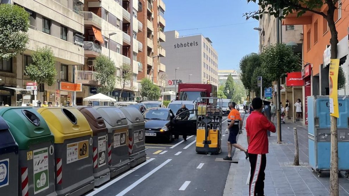 Los repartidores tienen dificultades por|para aparcar y tienen que ocupar el carril bici para descargar.