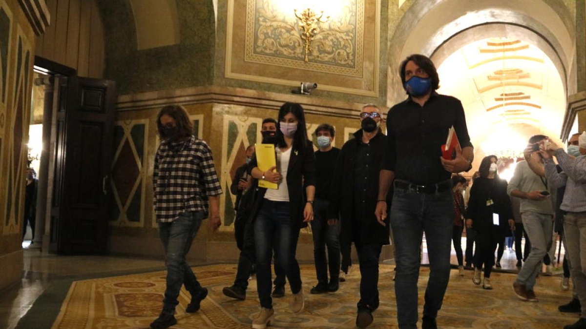 Pla general dels negociadors d'ERC, Junts i la CUP caminant pels passadissos del Parlament després de la reunió a tres bandes