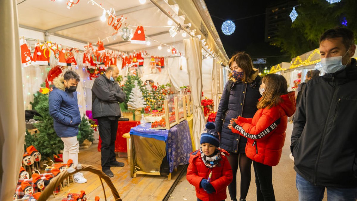 Imatge de diversos clients passejant pel tram de la Rambla on s'ha col·locat la Fira de Nadal.