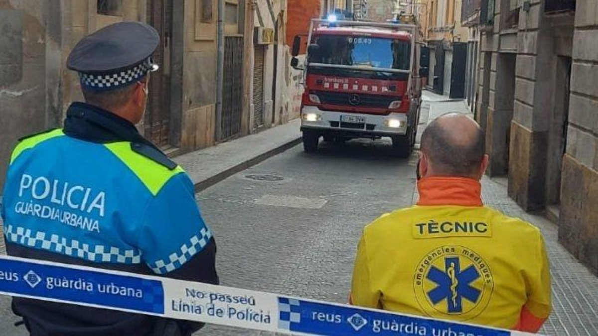 Un membre de la Guàrdia Urbana i del SEM observant el camió dels Bombers.