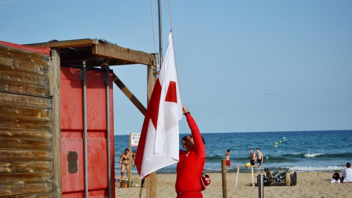 El personal de Cruz Roja izando la bandera.